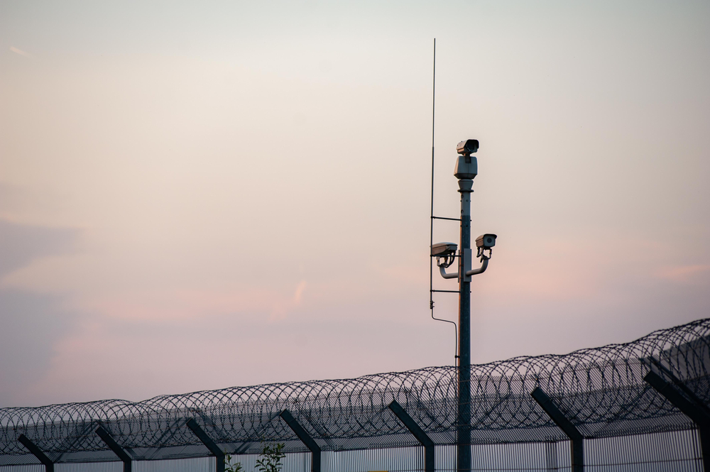 A pole with several cameras stands against a light background.